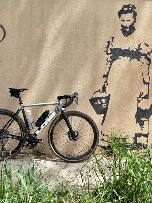 Gravel bike leaning against a mural-painted wall in Girona, Spain, during The Traka 200